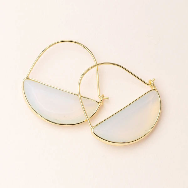 Two **Hoop Earring Opalite/Gold** by **Scout Jewelry** featuring semi-circle white opal stones are displayed against a light beige background. Hypoallergenic and 14K gold dipped, the earrings have a sleek and modern design, with the semi-precious stones framed by delicate gold outlines.