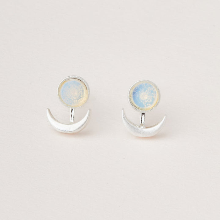 Introducing the Moon Phase Opalite/Silver earrings by Scout Jewelry, featuring crescent shapes with circular, opalescent stones against a plain white background. These hypoallergenic earrings offer both comfort and celestial elegance to enhance any outfit.