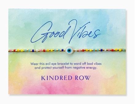 A vibrant, handmade beaded evil eye bracelet featuring natural gemstones is displayed on a card with a watercolor design. The text says, "Good Vibes. Wear this adjustable cord bracelet to ward off bad vibes and shield yourself from negative energy." At the bottom, you'll find the brand name "Kindred Row.