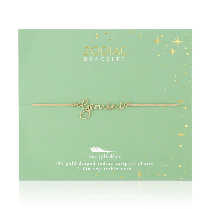 A delicate adjustable cord bracelet, part of the LuckyFeather collection, is embellished with the word "Gemini" in elegant gold script and presented on a light green card. This Zodiac Bracelet Gemini showcases a "14k gold-dipped zodiac scripted charm," beautifully highlighted by shimmering stars.