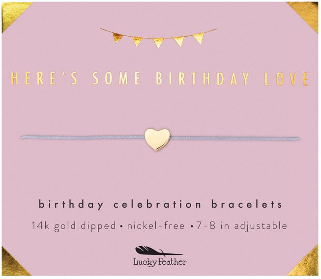 A pink card showcases the LuckyFeather Love Birthday bracelet, featuring a gold heart charm, with the message "Here's Some Birthday Love." This 14k gold dipped bracelet is both nickel-free and adjustable from 7 to 8 inches. The charming design is completed with a small banner at the top.