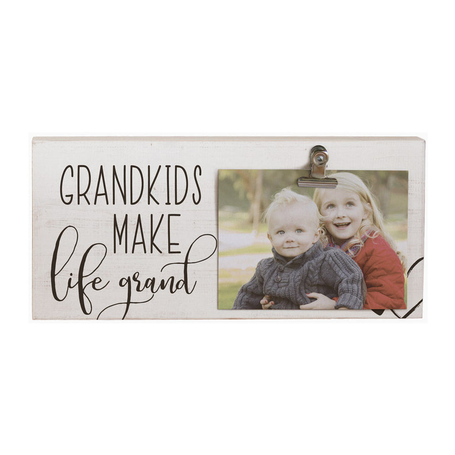 The "Grandkids make Life Grand" decorative sign by SincereSurroundings showcases a handcrafted, rustic design reminiscent of Rock Rapids, IA. It features a photo clipboard holding an image of two smiling children in an outdoor setting.