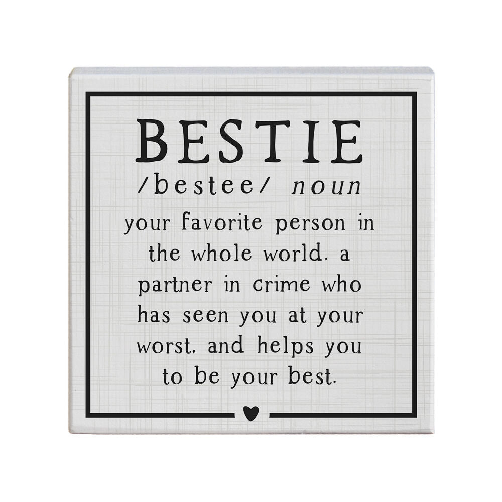 A square sign from SincereSurroundings, named "Bestie," features a light gray, grid-like background with the word "BESTIE" in large black letters at the top. Beneath it, a definition is provided: "/bestee/ noun, your favorite person in the world. A partner in crime who has seen you at your worst and helps you be your best." This handcrafted piece made in the USA also includes a small heart.