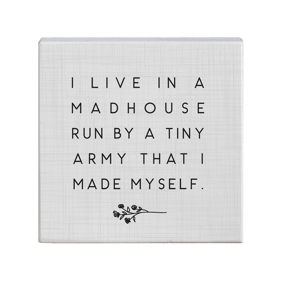 The handcrafted decorative canvas, "Tiny Army," from SincereSurroundings features the phrase, "I live in a madhouse run by a tiny army that I made myself," accompanied by a delicate floral design. It's an ideal addition to your shelf display, bringing character and charm to your space.