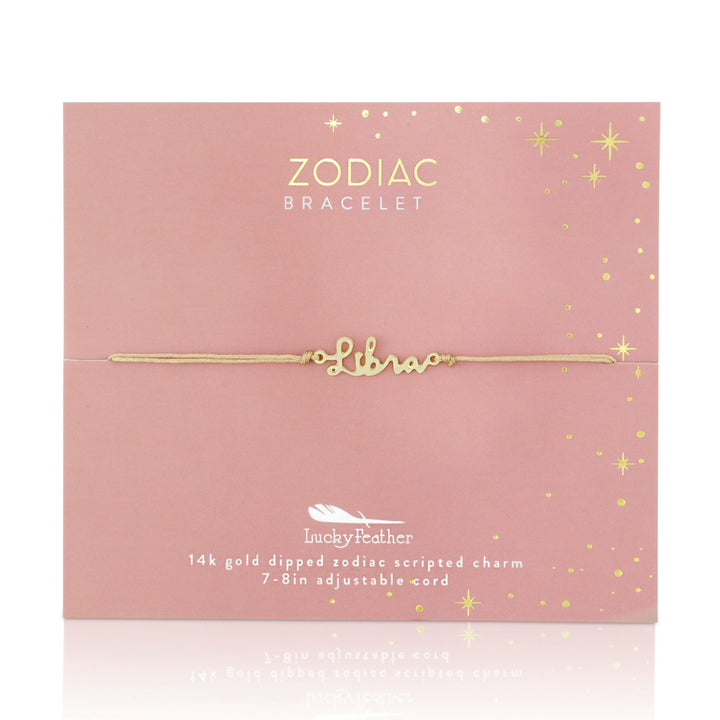 On a pink card, the "Zodiac Bracelet Libra" from LuckyFeather is showcased, featuring a gold bracelet beautifully inscribed with "Libra." Glittery star designs enhance the card, accentuating details of the 14k gold-dipped charm and adjustable cord bracelet for an ideal fit.