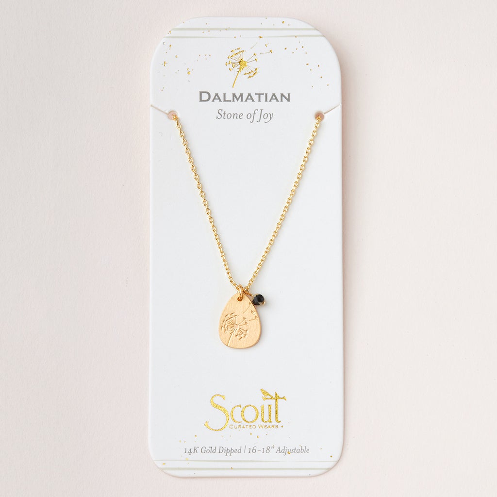 The Intention Neck Dalmatian/Gold by Scout Jewelry features a teardrop-shaped pendant with a small black bead on a 14K gold-dipped, adjustable 16-18'' chain. It reads "Dalmatian Stone of Joy" and "Scout Curated Wears," elegantly presented on a white card.