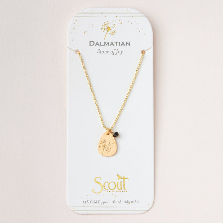 The Intention Neck Dalmatian/Gold by Scout Jewelry features a teardrop-shaped pendant with a small black bead on a 14K gold-dipped, adjustable 16-18'' chain. It reads "Dalmatian Stone of Joy" and "Scout Curated Wears," elegantly presented on a white card.