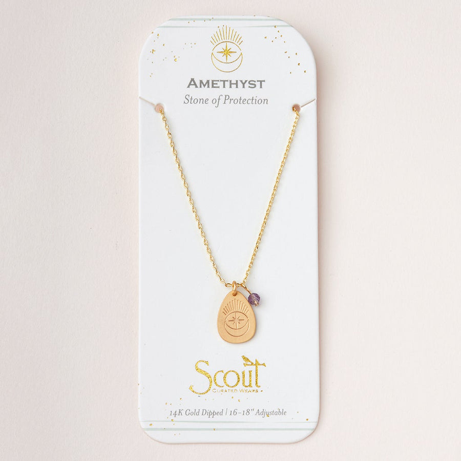 An "Intention Neck Amethyst/Gold" necklace by Scout Jewelry, featuring a pendant with a small amethyst stone, is displayed on a white card. The card reads "AMETHYST - Stone of Protection" and "Scout," along with "14K Gold Dipped 16”-18” Adjustable Brass Chain" at the bottom, finished with decorative gold accents.