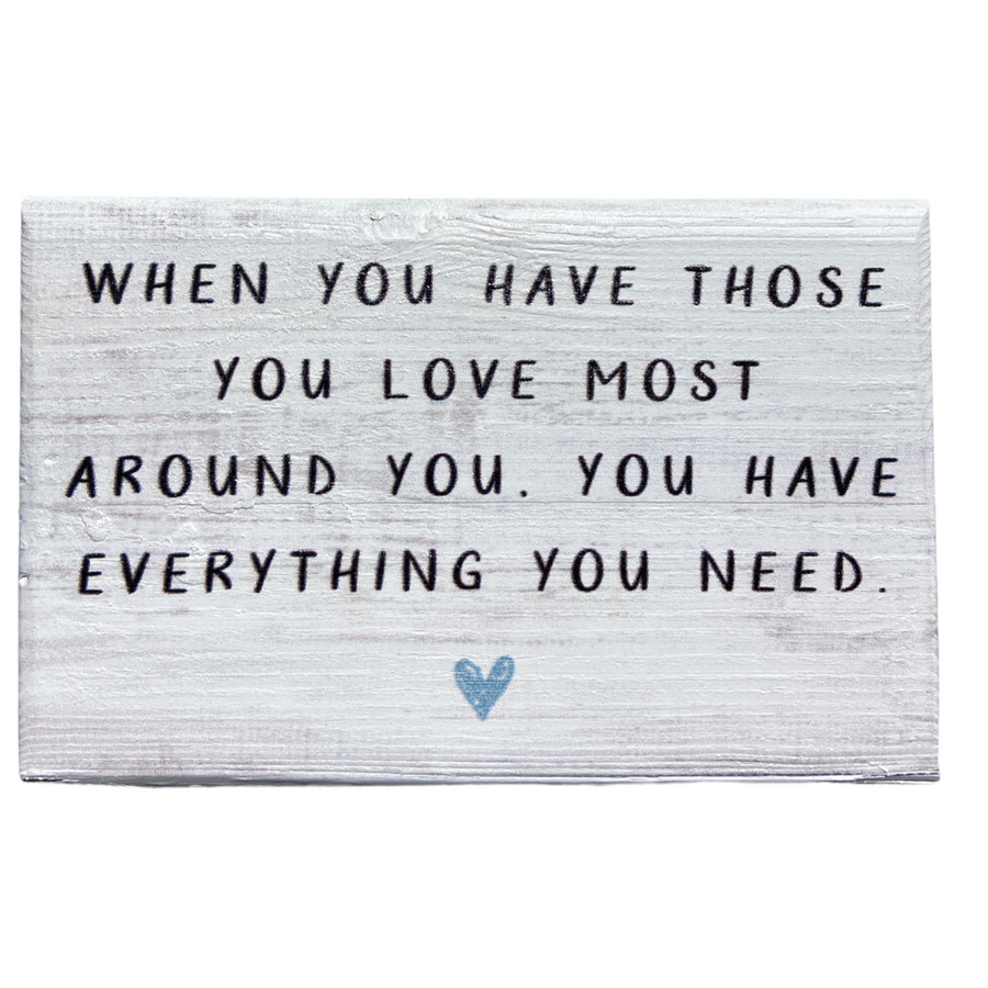 Under the brand name SincereSurroundings, "Those You Love" is a white wooden sign with black text that reads, "When you have those you love most around you, you have everything you need." Handcrafted with care, it also features a small blue heart at the bottom center for easy display.