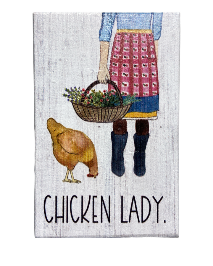 Illustration of a person in a blue top, purple skirt, and red apron holding a basket of flowers, standing next to a chicken. Handcrafted by SincereSurroundings and perfect to sit on your favorite shelf. Text at the bottom reads "CHICKEN LADY.