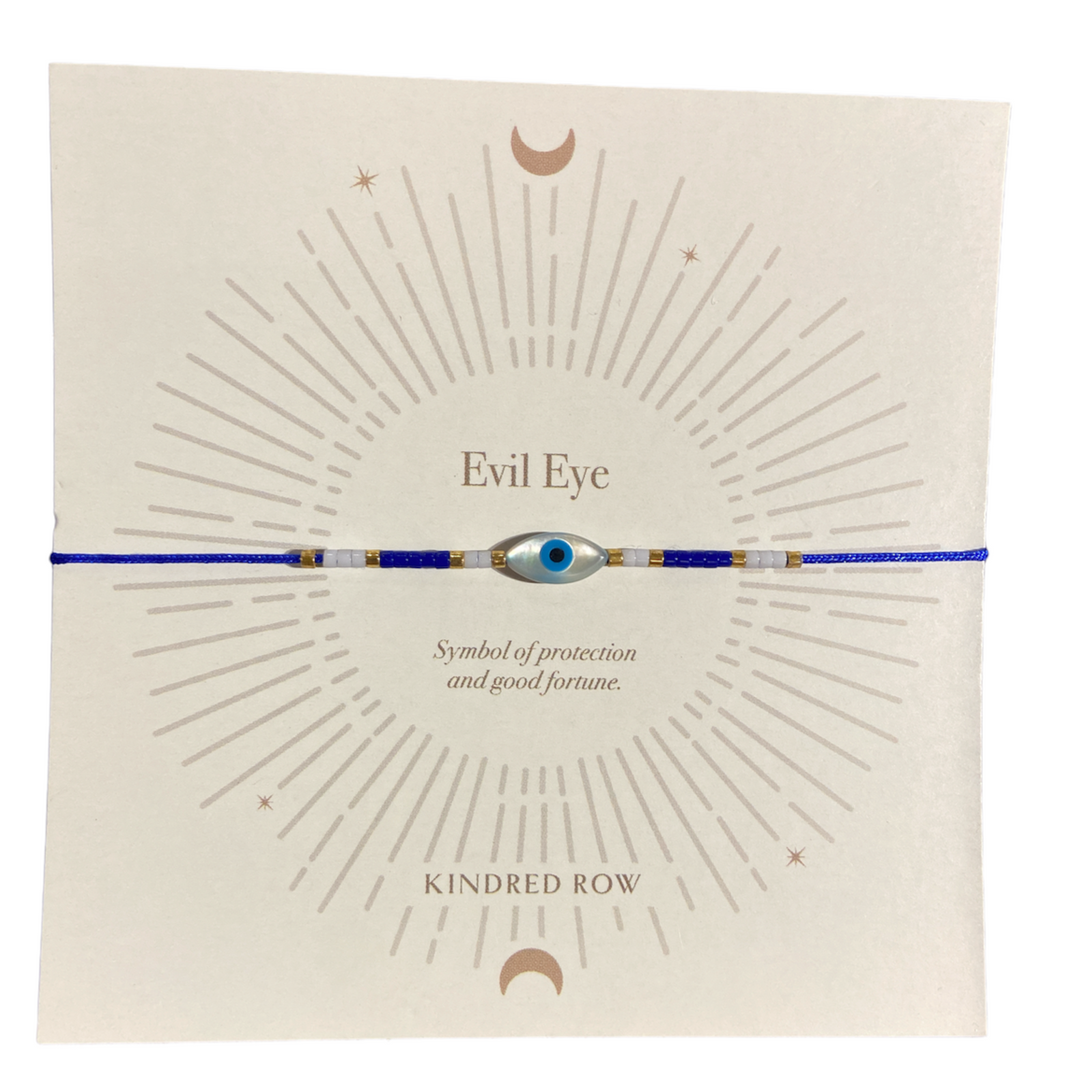 The Evil Eye Cord Bracelet Blue from Kindred Row is displayed on a card adorned with a sunburst design, crescent moon accents, and text reading "Evil Eye - Symbol of protection against bad luck and good fortune." The brand name "Kindred Row" is printed at the bottom.