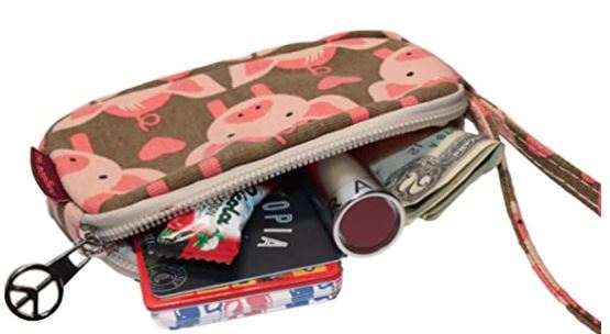 The Tiny Wristlet Pig by Bungalow 360 is partially open, showcasing a few dollar bills, a lip balm, a pack of mints, and other small items. This small, zippered pouch features a unique pink pig pattern and has a peace sign charm dangling from its zipper pull. It's perfect for those who support animal causes.