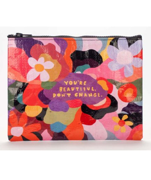 The Blue Q 'You're Beautiful' Zipper Pouch is a vibrant and colorful accessory featuring a lively floral pattern in reds, oranges, purples, and greens. Made from recycled material, the center text reads, "YOU'RE BEAUTIFUL, DON'T CHANGE.