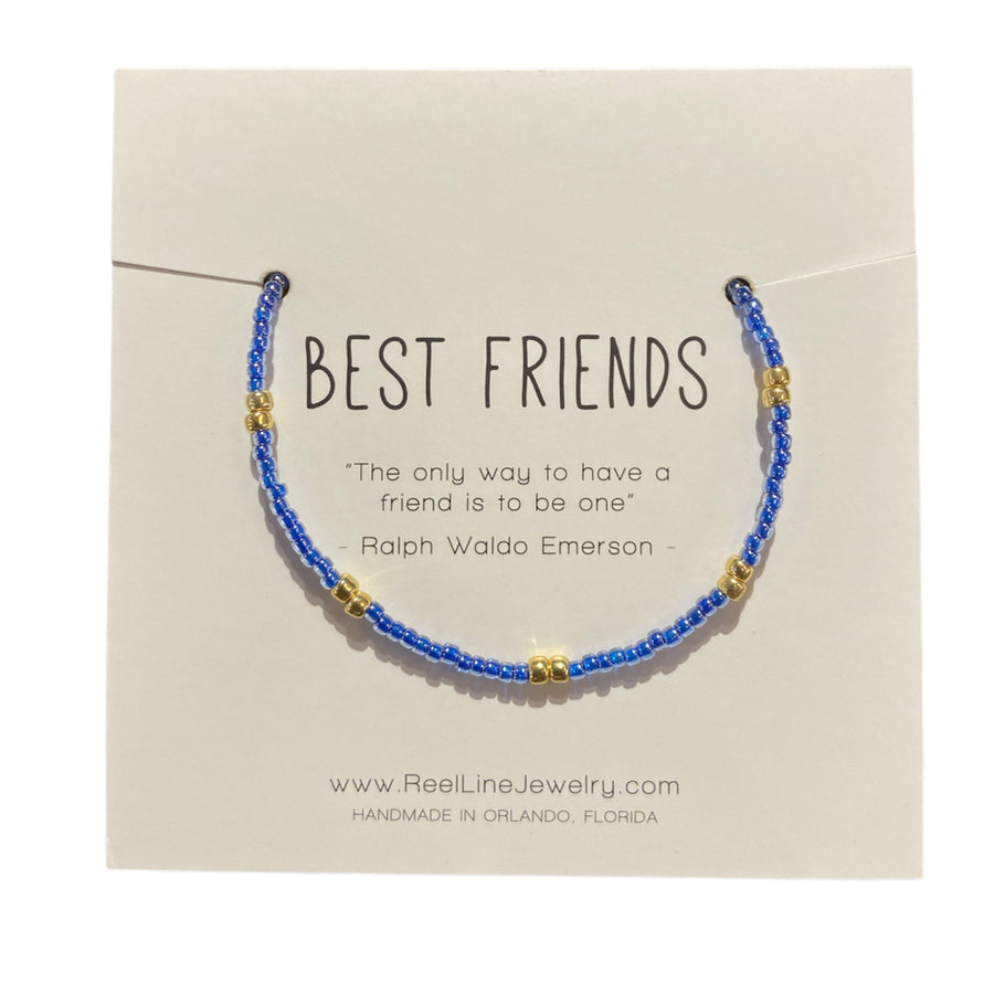 A thin glass beaded friendship bracelet featuring blue and gold colors is showcased on a card that reads "BEST FRIENDS" alongside a quote by Ralph Waldo Emerson: "The only way to have a friend is to be one." Handcrafted by Reel Line Jewelry, the adjustable links provide a perfect fit.