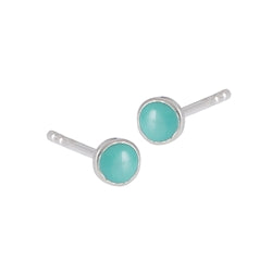 A pair of 4 mm stud earrings with turquoise set in sterling silver, designed by Welman to be mask-friendly, isolated on a white background.