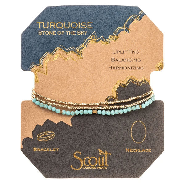 A package labeled "Turquoise/Gold Delicate Wrap" features a stunning bracelet and necklace made of gemstone beads. The text "Uplifting, Balancing, Harmonizing" appears above the turquoise and gold jewelry against a brown and gray background, with the brand name "Scout Jewelry" prominently visible.