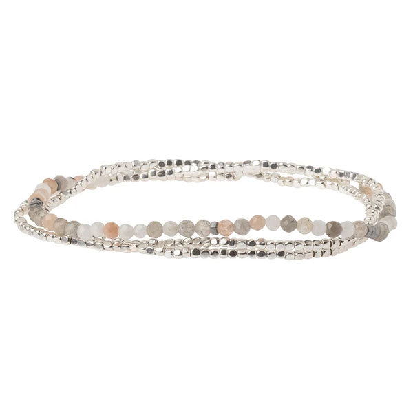 Introducing the Moonstone/Silver Delicate Wrap by Scout Jewelry, a graceful multi-strand bracelet adorned with plated brass, silver, and semi-precious gemstone beads in subtle shades of grey, beige, and light pink. The beads are arranged in an alternating pattern to create an understated yet sophisticated look that's perfect for both casual and formal occasions.