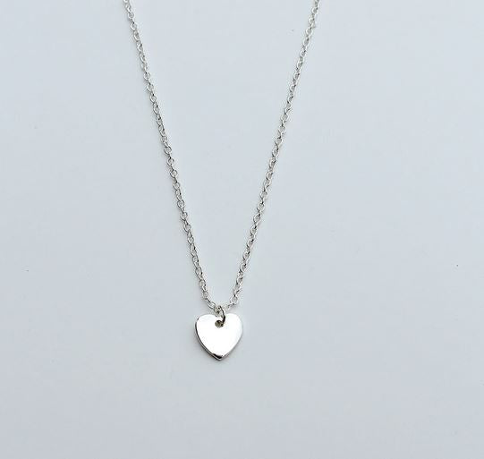 Introducing the Love you Million Bajillion necklace from LuckyFeather: a delicate silver chain featuring a nickel-free charm with a polished heart pendant. This elegant piece rests gracefully against any background and has an adjustable length for the perfect fit.