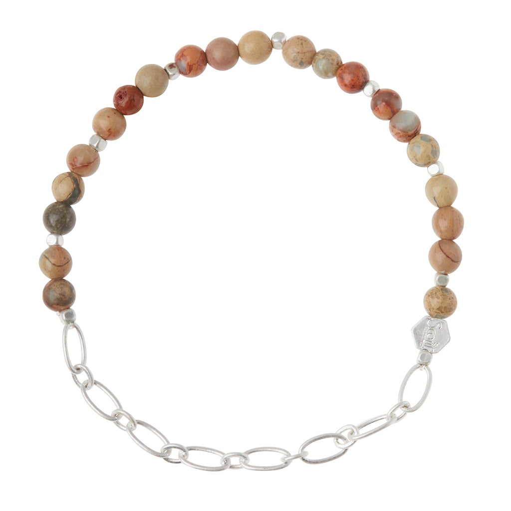 The Chain Bracelet Aqua Terra/Silver by Scout Jewelry showcases an elegant combination of round, earth-toned semi-precious gemstone beads in shades of brown, red, and gray alongside a silver paperclip chain. It is enhanced with an engraved logo bead and fastens gracefully with a silver clasp.