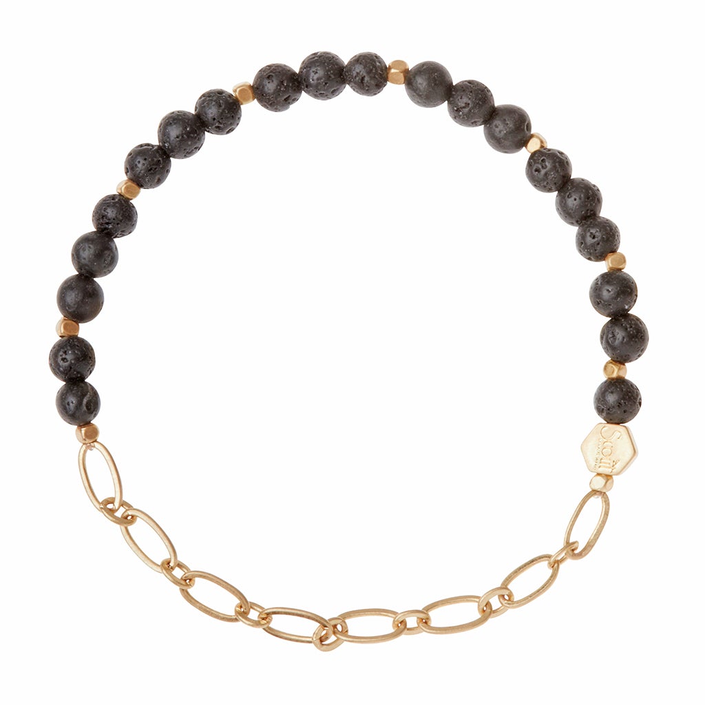 Introducing the Chain Bracelet Lava/Gold from Scout Jewelry, crafted with black lava rock beads and small gold spacer beads linked to a section of paperclip chain. It also features a delicate hexagonal gold tag for an elegant touch.