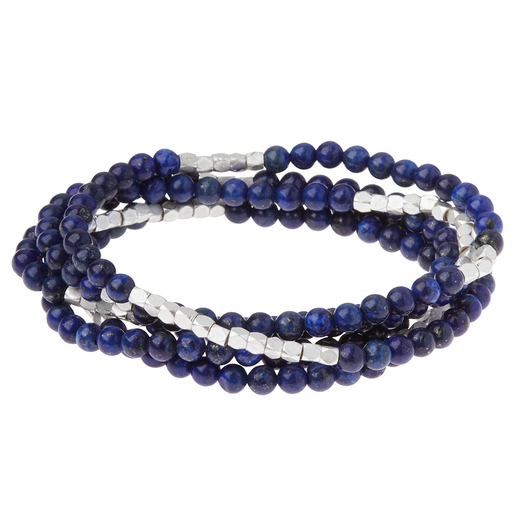 The "Stone Wrap Lapis Silver" set by Scout Jewelry showcases a trio of beaded bracelets, expertly crafted with dark blue semi-precious gemstones and small silver-toned beads in an eye-catching alternating pattern. These bracelets are beautifully layered in a coiled design against a white background.