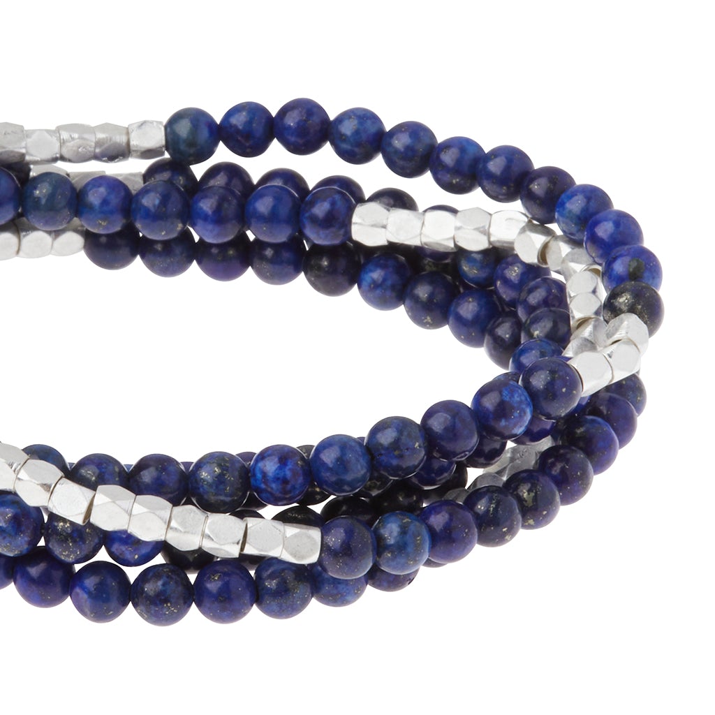 Close-up of the Stone Wrap Lapis Silver bracelet by Scout Jewelry, showcasing a multi-strand design with polished blue lapis lazuli stone beads and faceted silver-tone beads. The semi-precious gemstones create a striking contrast and add an extra touch of sophistication to this elegant piece.