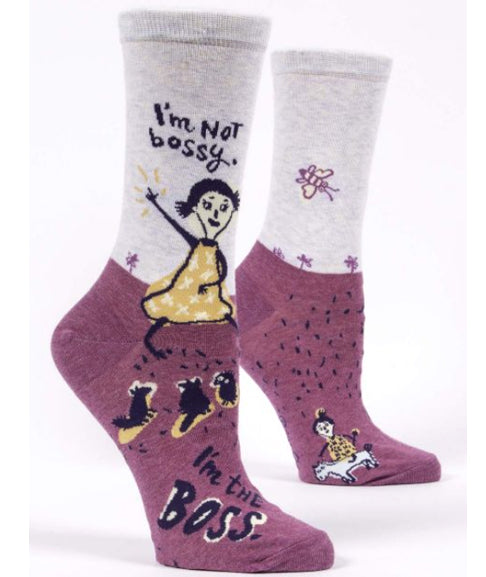 The Im not Bossy Socks from Blue Q feature a charming design tailored for women. The top half is light gray with a cartoon woman and the text "I'm not bossy," while the bottom half is purple with whimsical images, including a woman on a horse and the phrase "I'm the boss." Crafted from soft combed cotton, these socks pair perfectly with women's shoes.