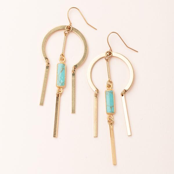 Introducing the Dreamcatcher Earring Turquoise Gold by Scout Jewelry: These 14k gold hoop earrings feature dangling linear accents with rectangular turquoise stones set in the center, suspended by small gold bars of varying lengths. The semi-precious stone earrings are nickel and cadmium free, exuding a modern and elegant appearance.