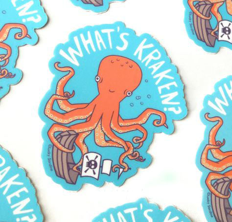 A whimsical illustration of an orange octopus holding a pirate ship with the text "WHAT'S KRAKEN?" in bold white letters against a blue background. The playful design appears on several weatherproof and dishwasher-safe What`s Kraken Pirate Ship Octopus Stickers by Lucky Sardine scattered across the image.