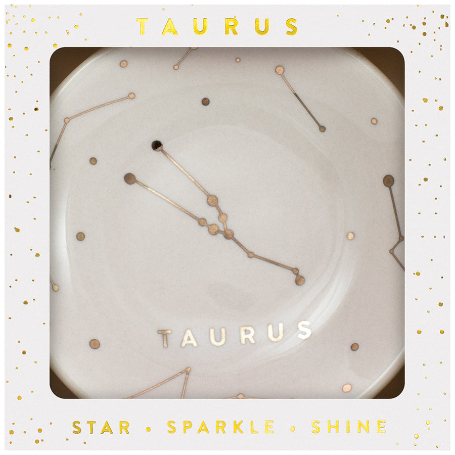 The LuckyFeather Dish Taurus is a white decorative trinket dish showcasing the Taurus constellation in gold. Packaged with "TAURUS" and "STAR SPARKLE SHINE" in gold on a white and gold starry background, it's ideal for jewelry storage and adds celestial charm to any space.