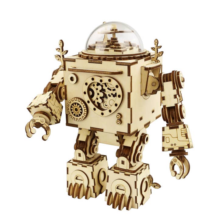 Introducing the DIY 3D Steampunk Music Box: Orpheus by Hands Craft—a wooden puzzle boasting intricate gears and a transparent dome head. It features articulated arms with claw-like hands and detailed, boxy legs, all highlighting its whimsical steampunk-inspired design.