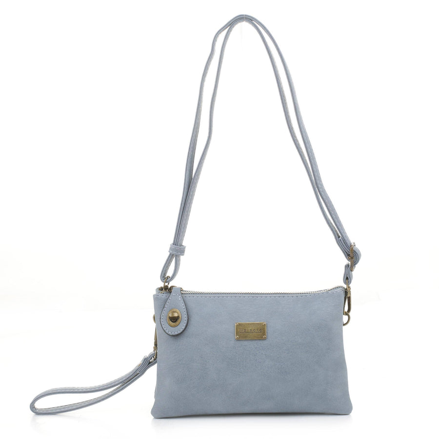 Introducing the Ella Crossbody - Blue from Liz Soto Handbags. This versatile leather crossbody bag is perfect for those who prefer to travel light. It boasts a detachable wrist strap and a secure zip closure, enhanced by a small rectangular metal logo plate on the front. The minimalist design stands out beautifully against its plain white background.