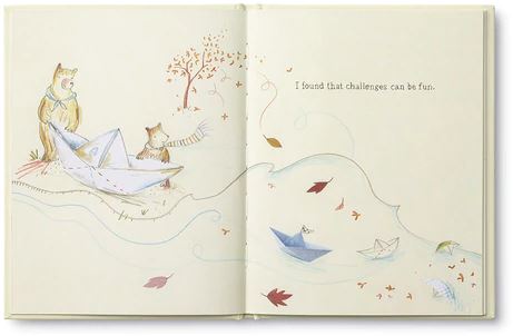 An illustrated page in "Because I Had a Teacher" shows a bear and a fox gazing at a paper boat on the riverbank, as the river flows from right to left, carrying more paper boats. Autumn leaves gently fall around them. The text on the right page reads, "I found that challenges can be fun." This touching book by COMPENDIUM makes for an ideal thank you gift for Teacher Appreciation Week.