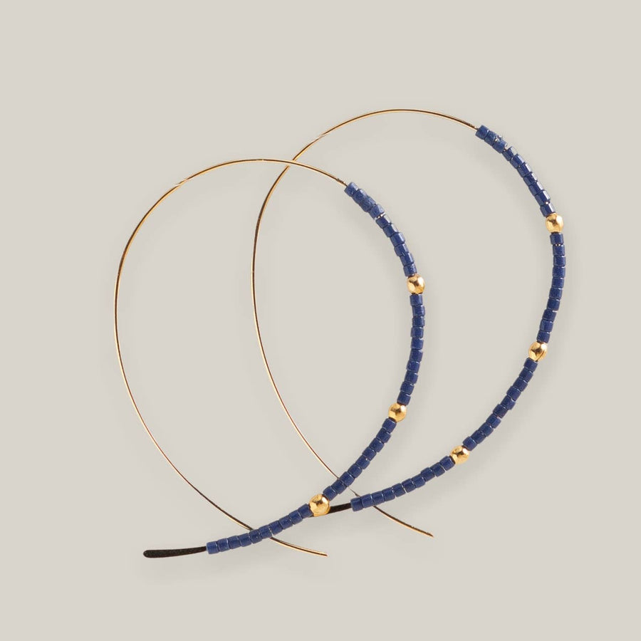 Displayed against a neutral background are two delicate headbands crafted from thin gold wire, featuring small blue Miyuki beads and evenly spaced gold accents.