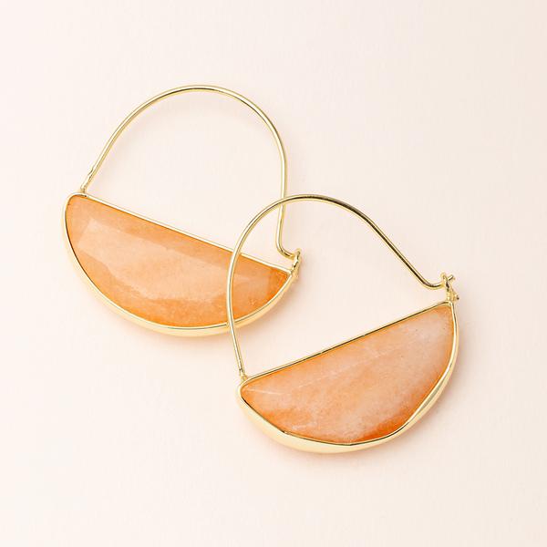 A pair of Scout Jewelry's Hoop Earring Sunstone/Gold, featuring semi-circular peach-colored semi-precious stone pendants, laid flat on a cream-colored background. The smooth and polished stones are encased in thin hypoallergenic 14K gold dipped settings, showcasing the minimalist design of these earrings.