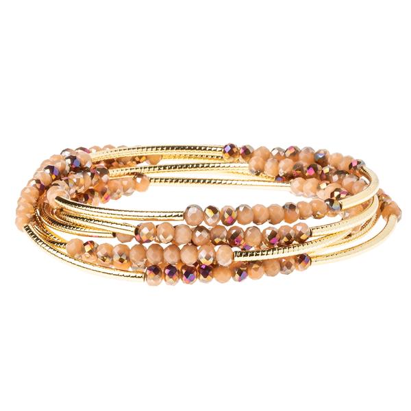 The Wrap Dune/Gold by Scout Jewelry showcases a set of layered bracelets with small, round crystal beads in shades of beige and brown, accented with etched metal findings. The Scout Wrap design features a coiled style that creates an elegant stacked appearance highlighted by gold-colored touches.