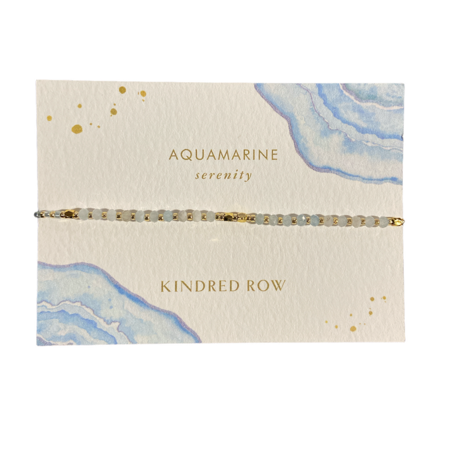 An elegant Amazonite Healing Gemstone Stacking Bracelet with an adjustable cord is paired with a card featuring watercolor designs and gold speckles. The words "Amazonite Serenity" alongside "Kindred Row" are beautifully printed, highlighting the allure of these natural gemstones.