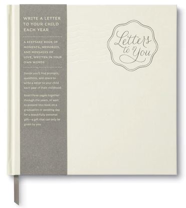 The "Letters To You" book by Compendium is a cream-colored keepsake with a gray spine, designed to help parents write yearly letters to their child. It features thoughtful prompts that assist in capturing cherished memories. This heartfelt gift is ideal for graduations or weddings.