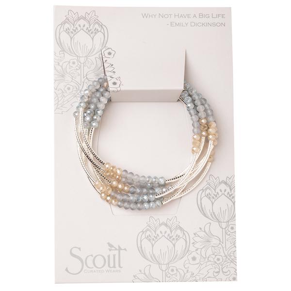 A set of multicolored crystal bead bracelets with silver accents, gracefully arranged on a floral-patterned card featuring Emily Dickinson's quote: "Why Not Have a Big Life." This delightful Wrap Mist Combo by Scout Jewelry makes for the perfect gift, with "Scout" proudly displayed at the bottom.