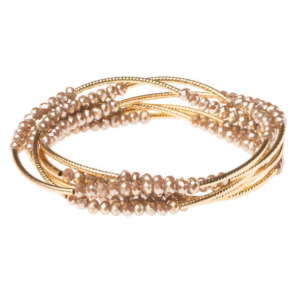 The Wrap Oyster/Gold bracelet by Scout Jewelry showcases gleaming gold bands woven together with clusters of small, round, faceted crystal beads, creating an elegant and intricate design ideal for personalized gifts.