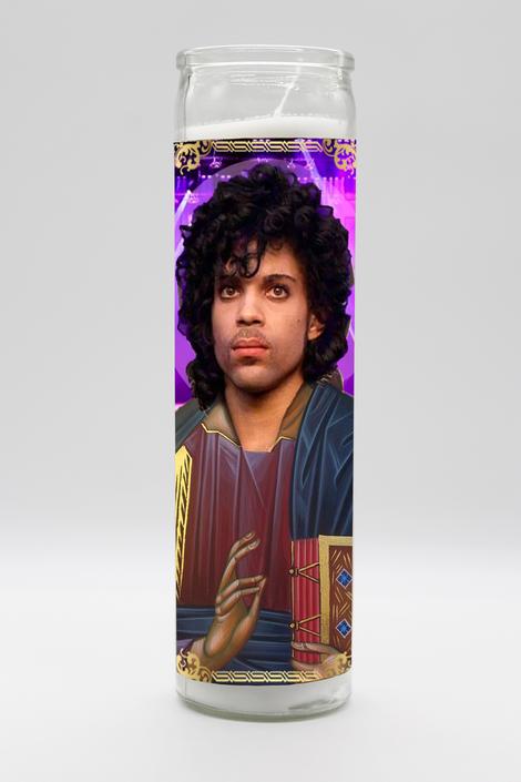 The Prince Candle from BOBBYK BOUTIQUE is an unscented candle featuring a curly-haired portrait against a "Purple Rain" themed purple background, with elegant gold-colored details.