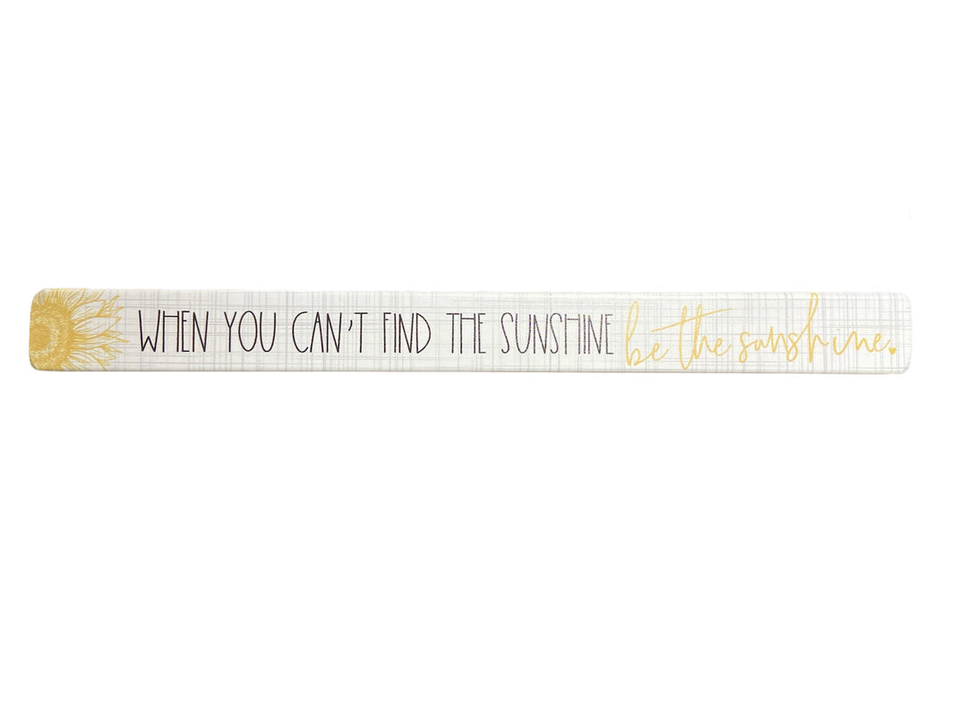 The "Be The Sunshine" plaque by SincereSurroundings is a handcrafted decorative piece made from real wood. It showcases a sunflower design on the left and displays the message, "WHEN YOU CAN'T FIND THE SUNSHINE, be the sunshine," with "be the sunshine" elegantly scripted in cursive. Ideal for display.