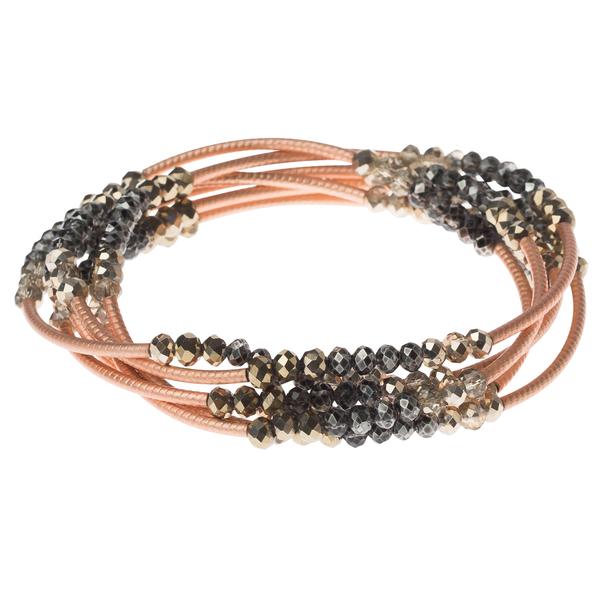 Introducing the Scout Jewelry Wrap tri tone/matte rose gold: a set of intertwined elastic bracelets adorned with faceted black and tri-tone beads on peach-colored cords, elegantly arranged in a circle.