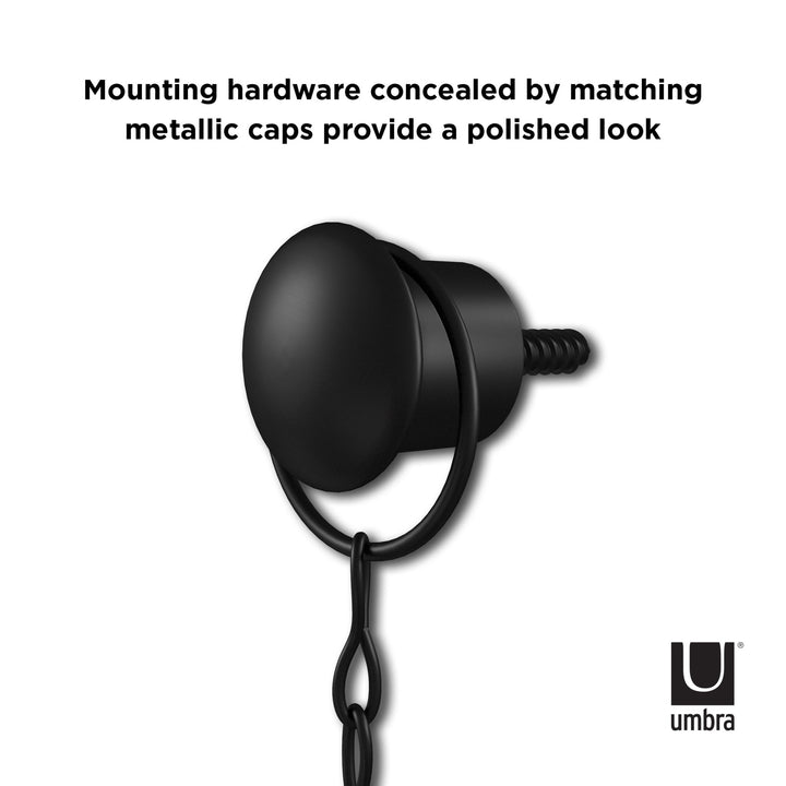 Close-up of the Umbra Diamond Mirror Black, featuring a black, spherical wall-mounted hardware piece with a button-like quality and matching metallic cap, expertly concealing the mounting hardware. The text above reads, "Mounting hardware concealed by matching metallic caps provide a polished look." The Umbra logo is in the bottom right corner.