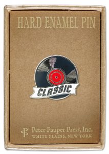 Introducing the Vinyl Pin by PeterPauperP: A meticulously crafted hard enamel pin designed in the shape of a vinyl record, featuring a striking red center and adorned with the word "Classic". It is elegantly presented on a brown cardboard backing with descriptive text and arrives beautifully packaged in a straightforward gift box, making it an exceptional keepsake for music enthusiasts.